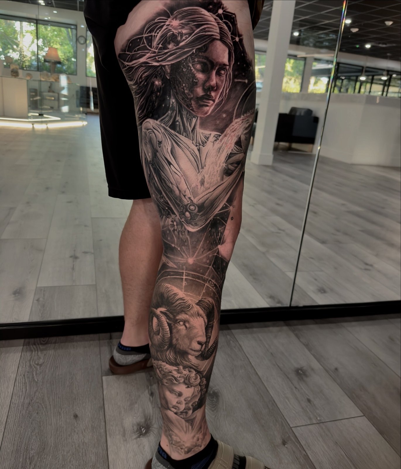 Black and grey full leg sleeve with celestial woman, constellations, Aries ram and cherub
